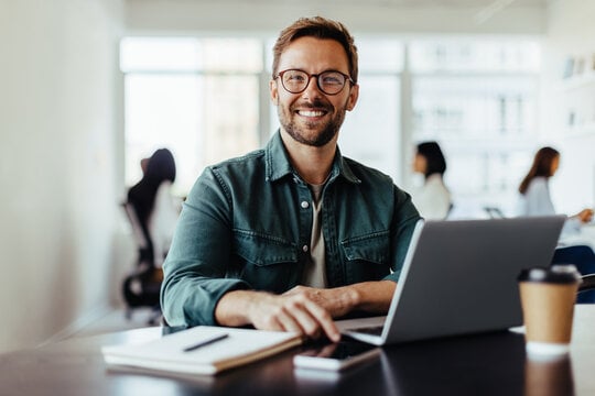 a man in front of his work laptop