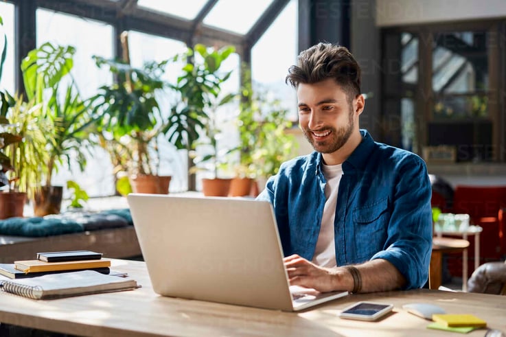 smiling professional in front of his laptop