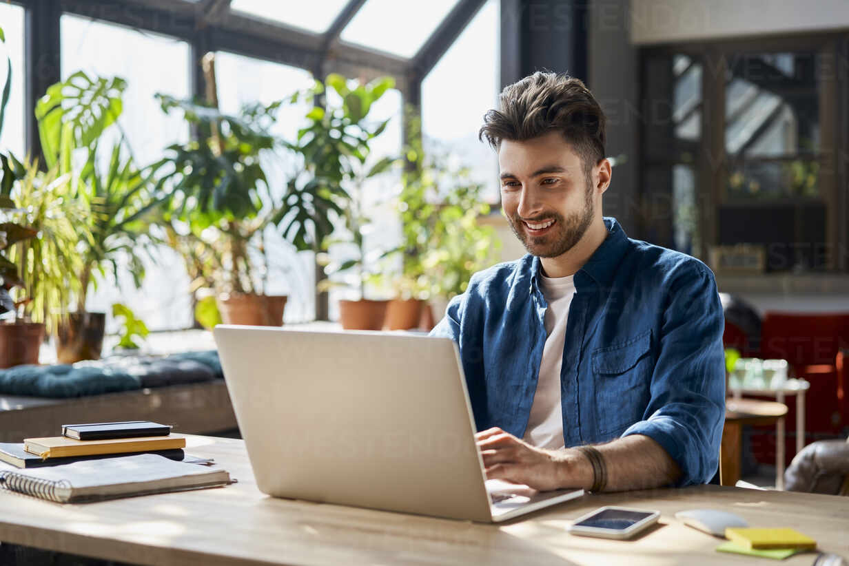 smiling professional in front of his laptop